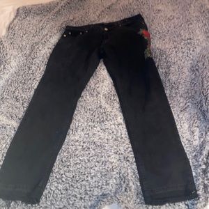 Mens jeans with rose detail patch on one leg.